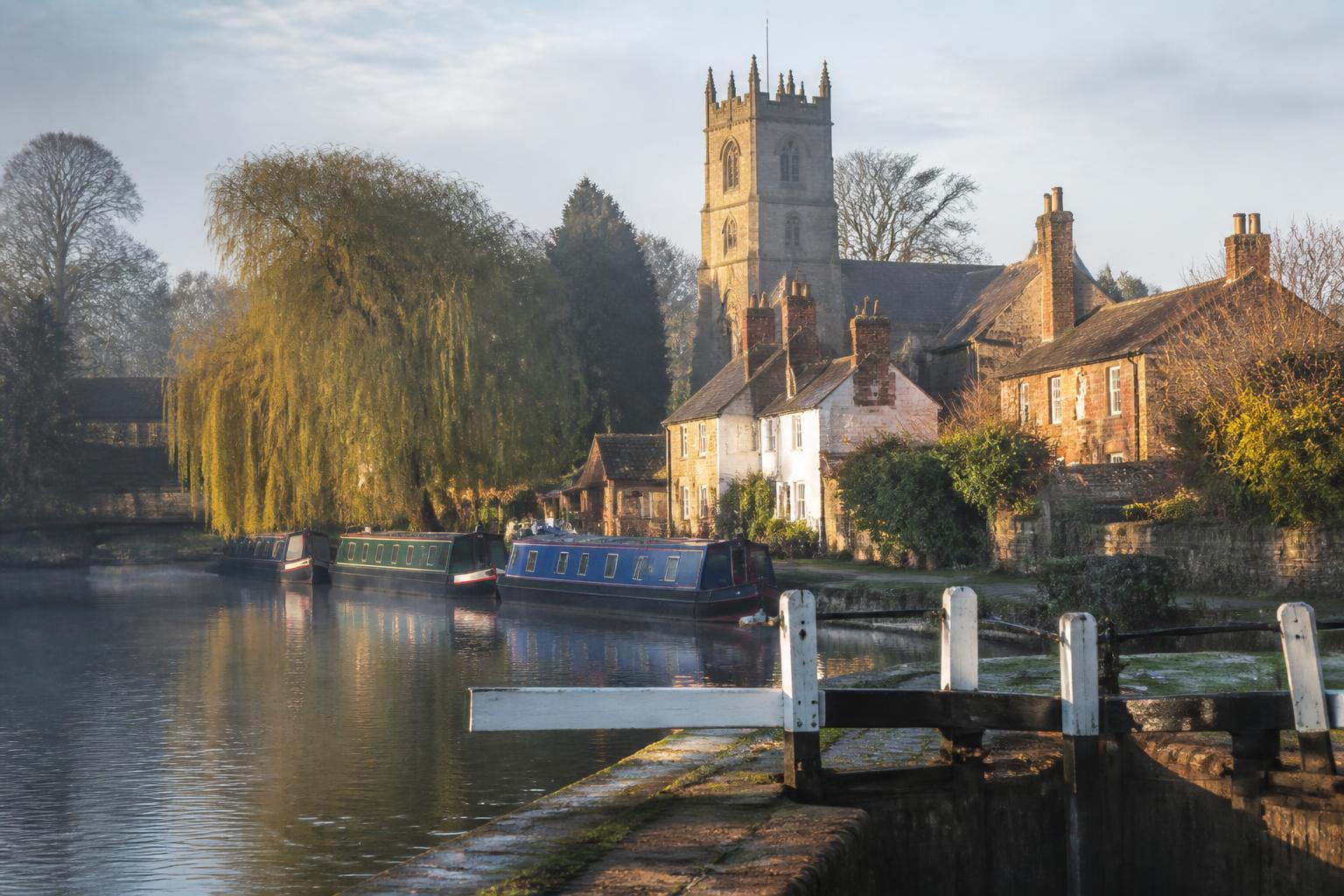 Barrow upon Soar canal lock with narrowboats and Holy Trinity church